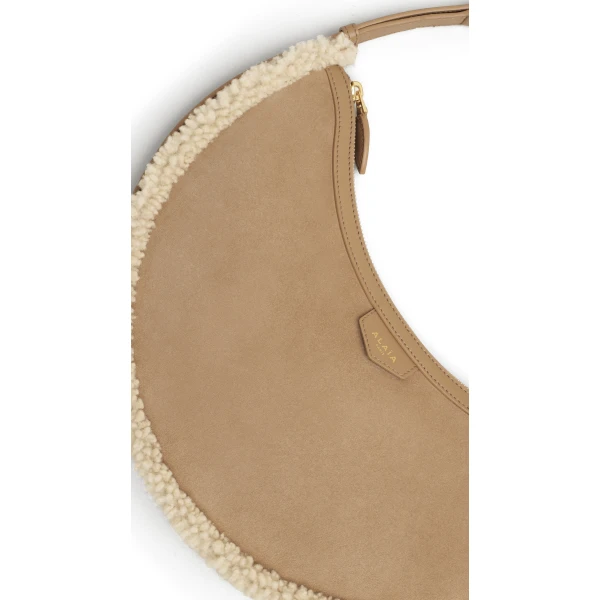 Alaia One Piece Demi Lune Bag in Merino Shearling, Camel | Shoulder & Crossbody Bags | Coveti