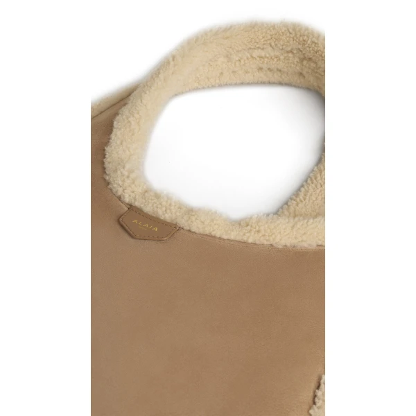 Alaia One Piece Hobo Bag in Merino Shearling, Camel | Shoulder & Crossbody Bags | Coveti